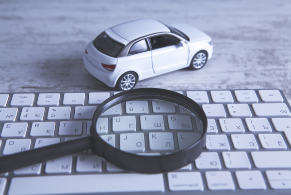 Small car next to keyboard and magnifying glass