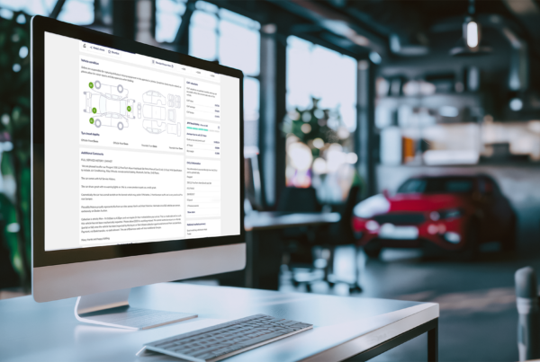 Screen showing Dealer Auction platform with splat drawing of car, car shown in showroom behind.